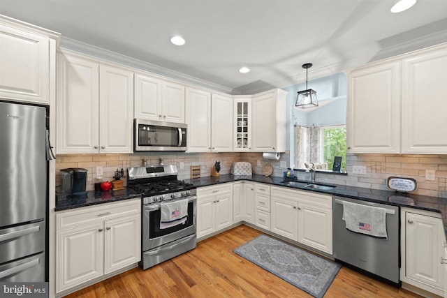 kitchen with appliances with stainless steel finishes, a sink, white cabinetry, recessed lighting, and decorative backsplash
