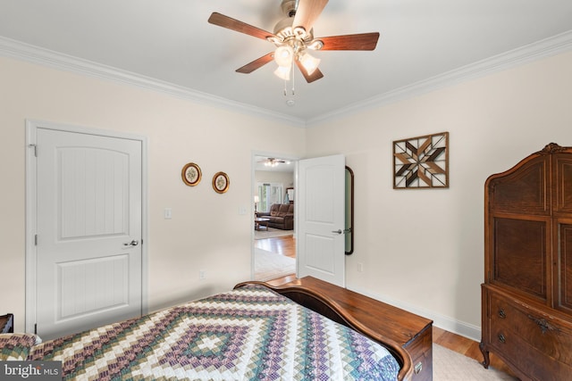 bedroom with crown molding, wood finished floors, a ceiling fan, and baseboards