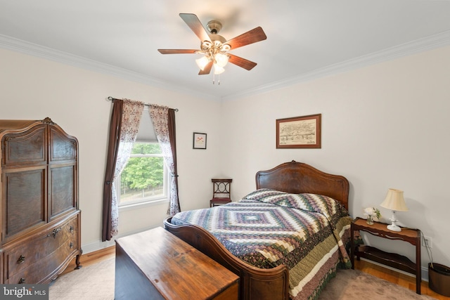 bedroom with ornamental molding, light wood-style floors, a ceiling fan, and baseboards
