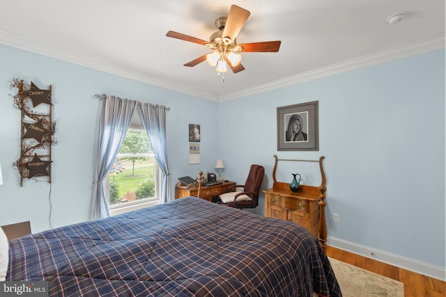 bedroom featuring ornamental molding, wood finished floors, baseboards, and a ceiling fan