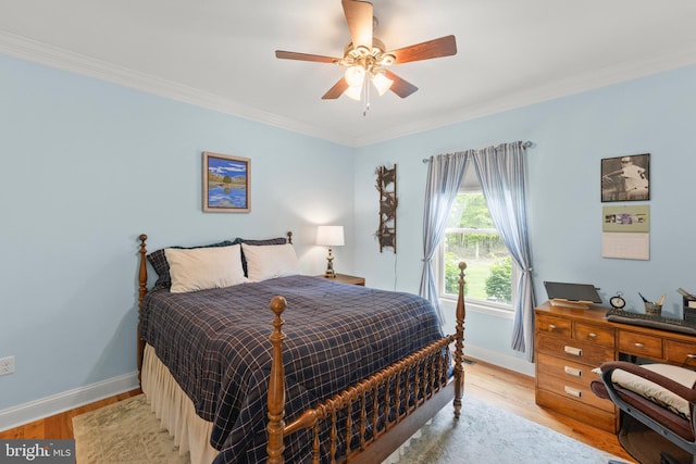 bedroom featuring baseboards, crown molding, light wood finished floors, and ceiling fan