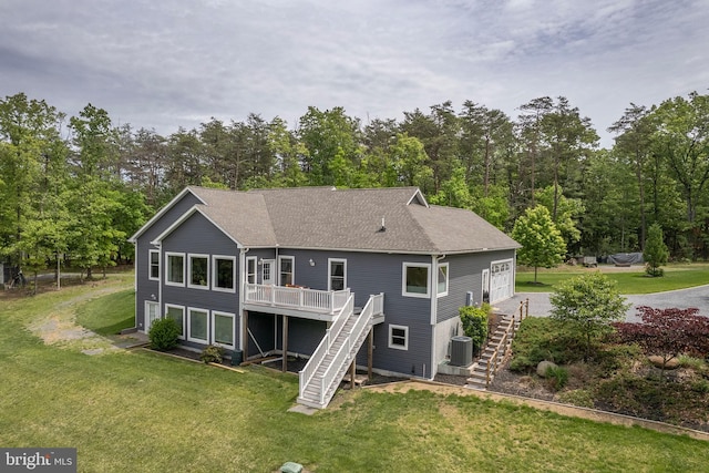 rear view of property with stairs, a deck, central AC, a yard, and a shingled roof