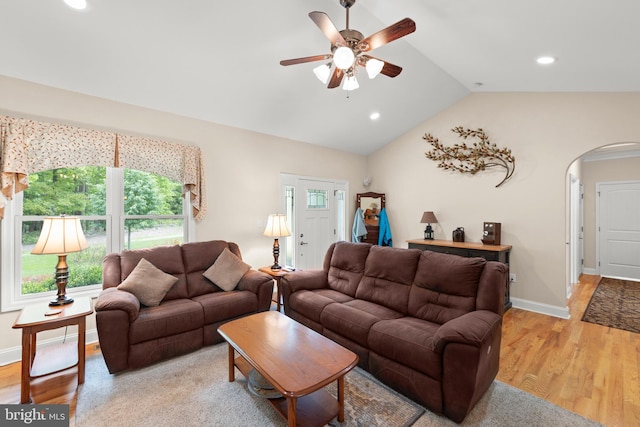 living area featuring arched walkways, ceiling fan, light wood finished floors, recessed lighting, and vaulted ceiling