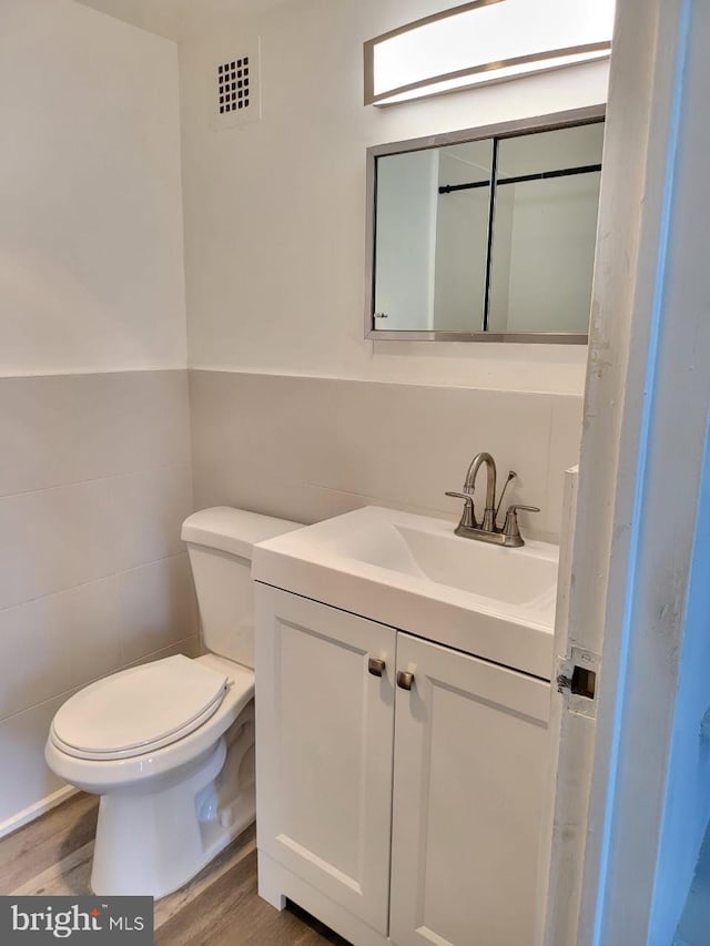 6631 Wakefield Dr Unit 804, Alexandria, VA 22307 - bathroom with visible vents, wood finished floors, toilet, and tile walls
