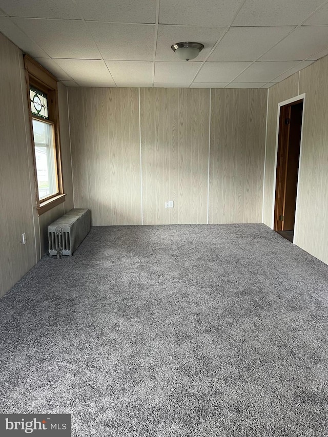 451 Main St, Ashland, PA 17921 - carpeted spare room with a paneled ceiling, radiator heating unit, and wooden walls