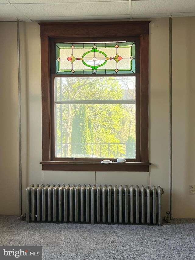 451 Main St, Ashland, PA 17921 - detailed view of radiator heating unit, carpet flooring, and a drop ceiling