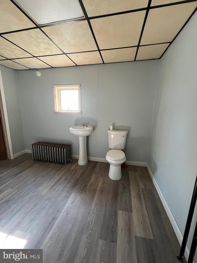 451 Main St, Ashland, PA 17921 - half bathroom featuring wood finished floors, toilet, baseboards, radiator heating unit, and a sink
