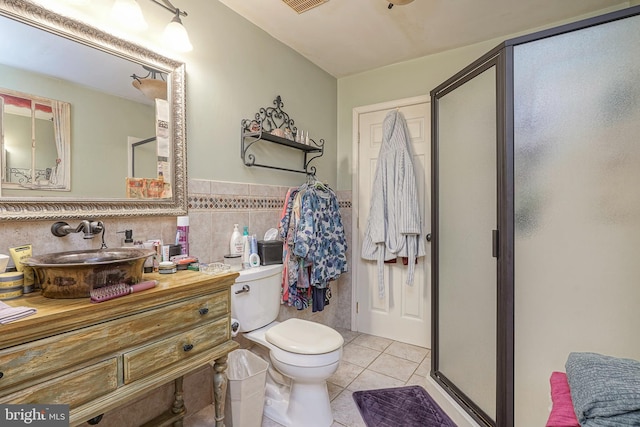bathroom featuring tile patterned floors, a shower stall, tile walls, toilet, and vanity