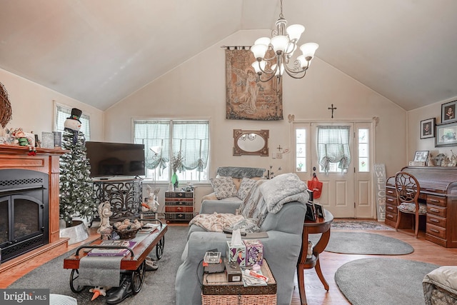 living area with a fireplace with raised hearth, high vaulted ceiling, wood finished floors, and a chandelier