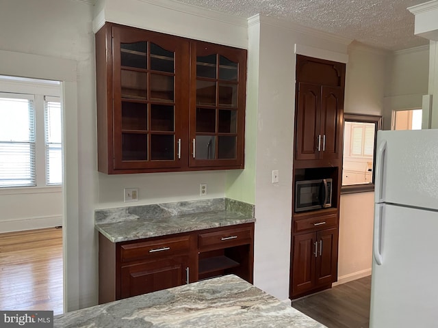 854 View St, Hagerstown, MD 21742 - kitchen featuring freestanding refrigerator, stainless steel microwave, glass insert cabinets, dark wood-style floors, and a textured ceiling