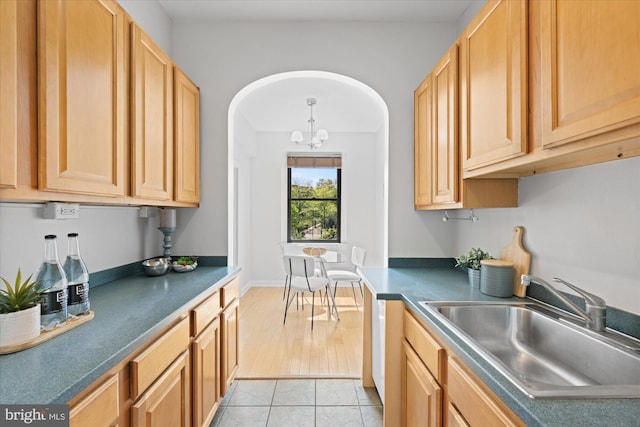 4007 Connecticut Ave NW Unit 302, Washington, DC 20008 - kitchen with dark countertops, a sink, a notable chandelier, and light tile patterned flooring