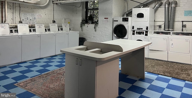 4007 Connecticut Ave NW Unit 302, Washington, DC 20008 - kitchen featuring stacked washer and dryer, tile patterned floors, white cabinets, and washer and clothes dryer