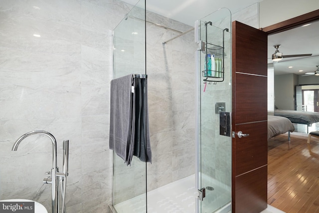 full bathroom with ceiling fan, a stall shower, ensuite bath, and wood finished floors