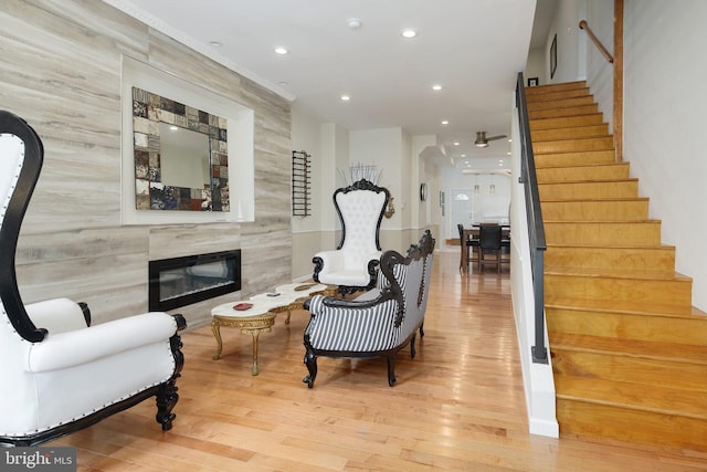 living area featuring stairway, a fireplace, recessed lighting, and wood finished floors