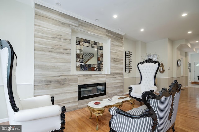 living area featuring recessed lighting, wood finished floors, and a premium fireplace