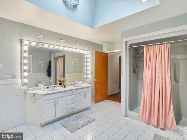 11416 Kline Dr NW, Cumberland, MD 21502 - bathroom with tile patterned floors, curtained shower, double vanity, a wainscoted wall, and tile walls