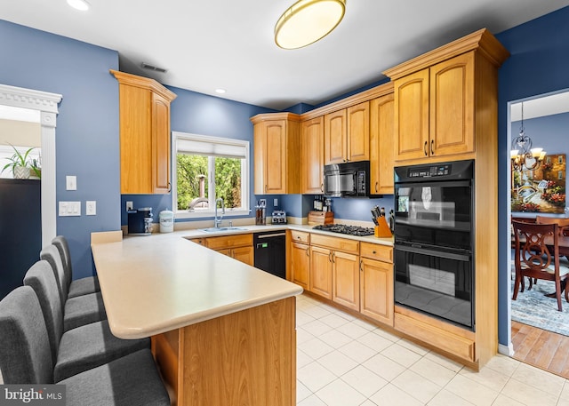 137 E Holly, Haddon Township, NJ 08107 - kitchen featuring black appliances, light countertops, a breakfast bar, a peninsula, and a sink