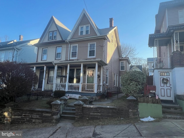 view of front of house with a chimney and a porch