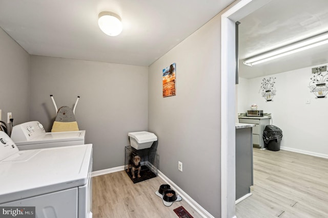 laundry area with independent washer and dryer, light wood finished floors, and baseboards