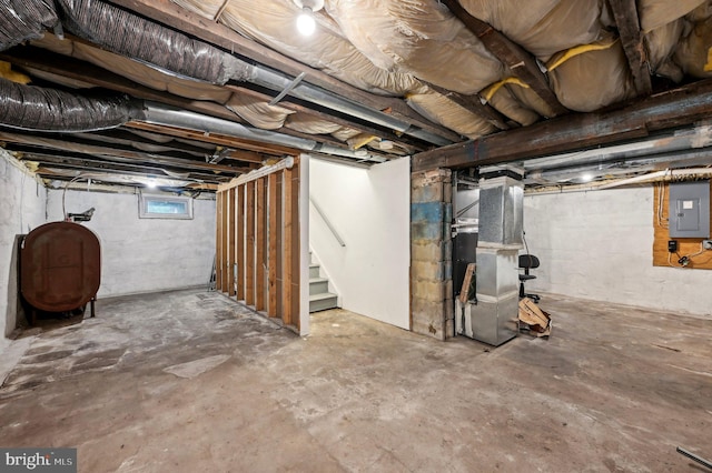 basement with oil tank, electric panel, stairway, and heating unit