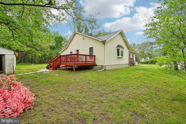 rear view of house with a wooden deck and a yard