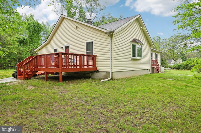 rear view of house featuring a deck and a yard