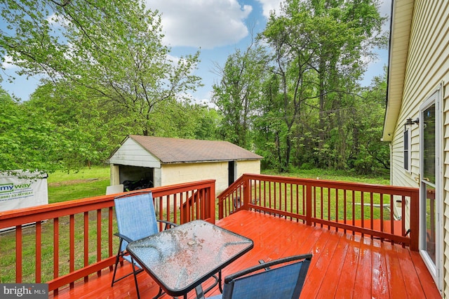 deck featuring outdoor dining space, a lawn, and an outbuilding