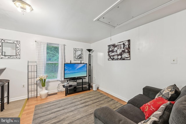 living room with attic access, wood finished floors, and baseboards