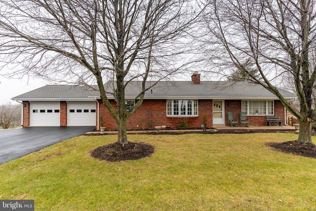 single story home featuring brick siding, a front lawn, driveway, and an attached garage