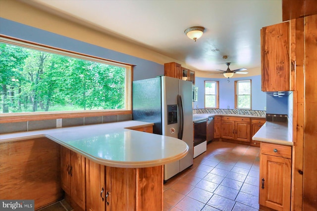 7395 Jonestown Rd, Harrisburg, PA 17112 - kitchen with brown cabinets, light tile patterned flooring, light countertops, stainless steel appliances, and a ceiling fan