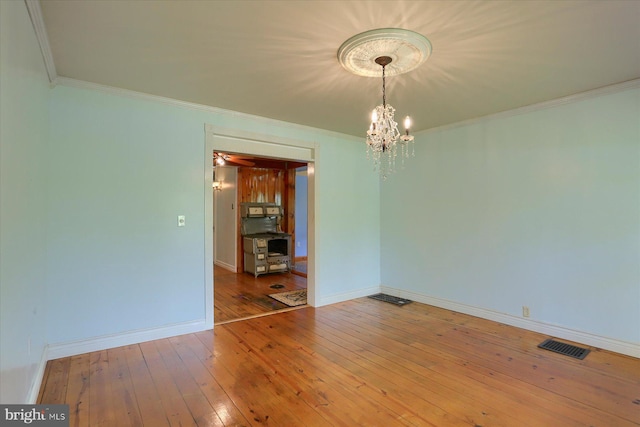 7395 Jonestown Rd, Harrisburg, PA 17112 - empty room with visible vents, baseboards, a notable chandelier, ornamental molding, and hardwood / wood-style floors