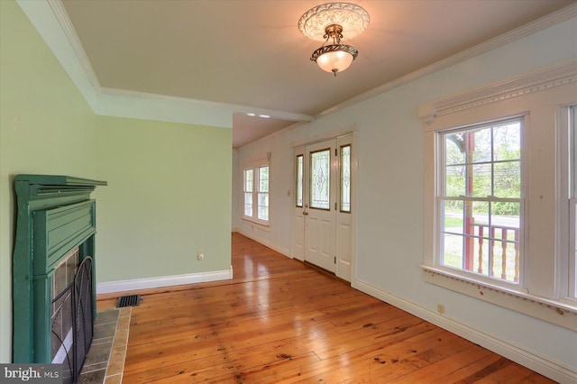 7395 Jonestown Rd, Harrisburg, PA 17112 - unfurnished living room with crown molding, visible vents, baseboards, light wood-type flooring, and a fireplace with flush hearth