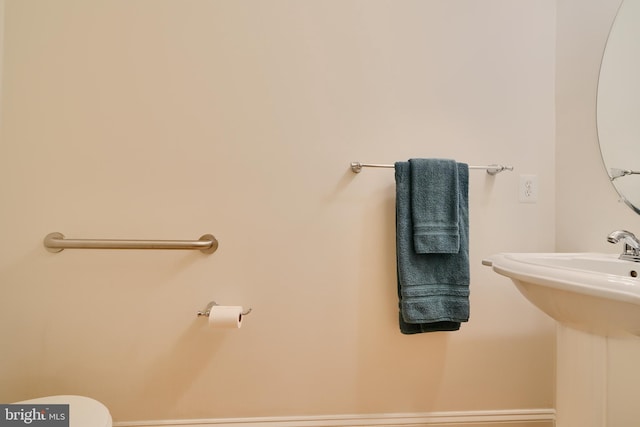 bathroom with toilet and baseboards