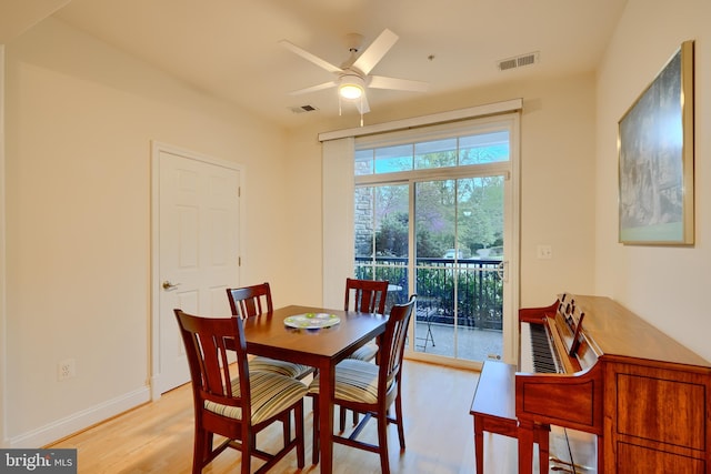 dining area with light wood finished floors, baseboards, visible vents, and ceiling fan
