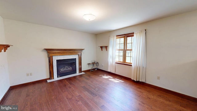 unfurnished living room featuring baseboards, visible vents, wood finished floors, and a tile fireplace