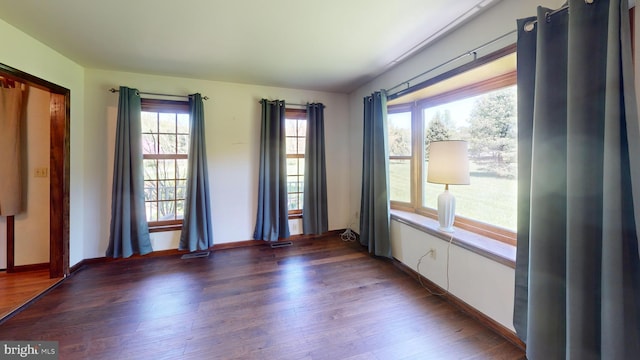 spare room featuring baseboards, wood finished floors, and visible vents