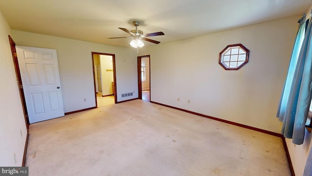 unfurnished bedroom with baseboards, ceiling fan, light colored carpet, and visible vents