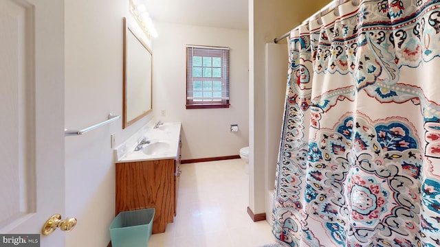 bathroom with vanity, baseboards, curtained shower, and toilet