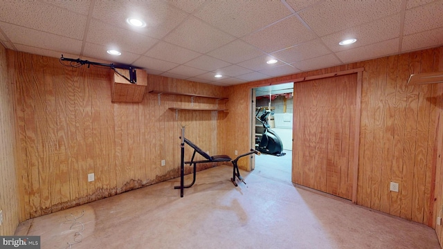 finished basement featuring wooden walls, recessed lighting, and a paneled ceiling
