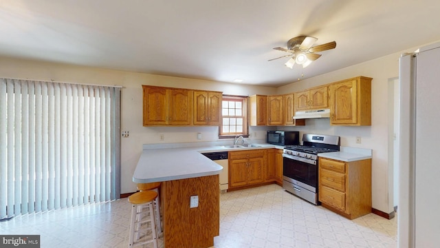 kitchen featuring white dishwasher, black microwave, stainless steel gas stove, a peninsula, and under cabinet range hood