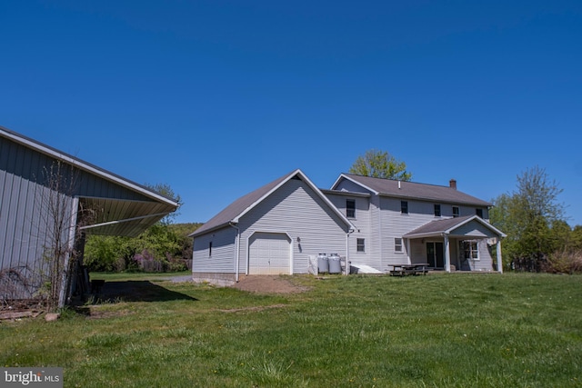 back of property featuring a lawn and an attached garage