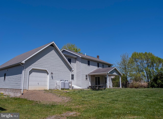 view of property exterior with a garage, a chimney, and a lawn