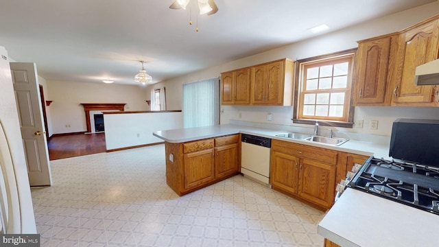 kitchen with white dishwasher, a sink, light countertops, a peninsula, and light floors