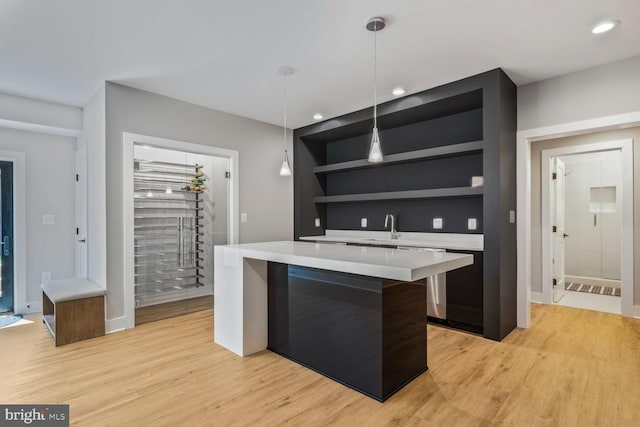 2600 3rd St N, Arlington, VA 22201 - kitchen featuring open shelves, hanging light fixtures, light wood-style floors, light countertops, and a kitchen island