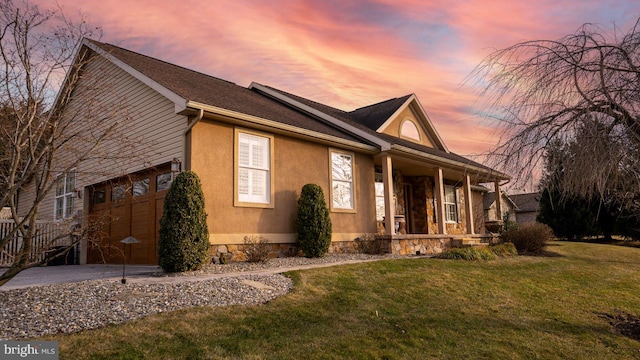 1222 Brian Ln, Hanover, PA 17331 - view of front facade with a porch, a lawn, stucco siding, a garage, and driveway