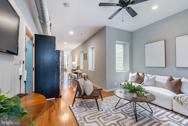 living room with ceiling fan, baseboards, light wood finished floors, and recessed lighting