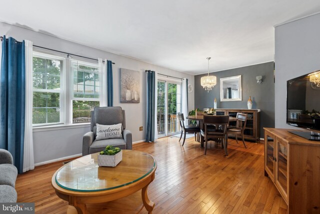 12328 Woodlawn Ct, Woodbridge, VA 22192 - living area with a chandelier, light wood-style flooring, and baseboards