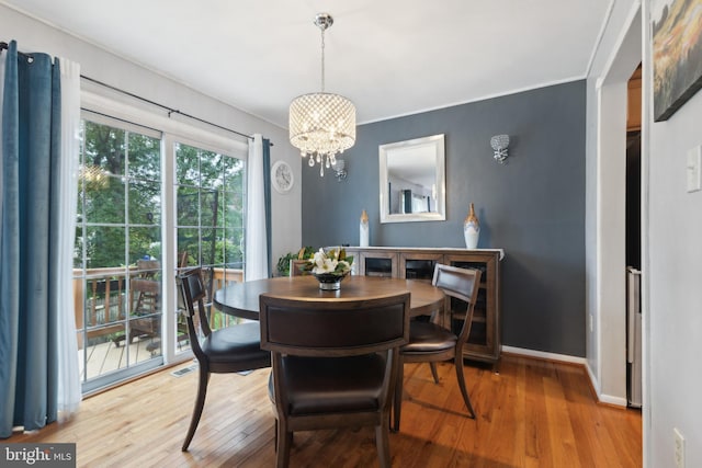 12328 Woodlawn Ct, Woodbridge, VA 22192 - dining space with wood finished floors, a chandelier, and baseboards