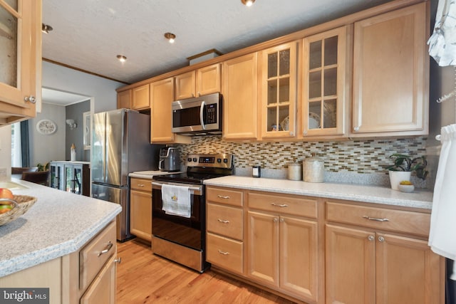 12328 Woodlawn Ct, Woodbridge, VA 22192 - kitchen featuring stainless steel appliances, crown molding, light countertops, light wood finished floors, and tasteful backsplash
