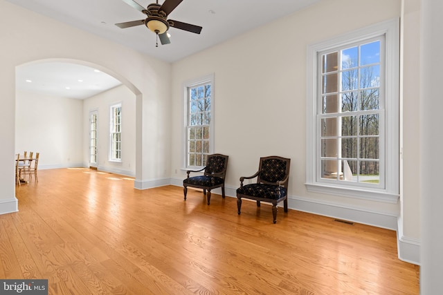 14815 Dover Rd, Reisterstown, MD 21136 - living area with arched walkways, light wood-style floors, baseboards, visible vents, and a ceiling fan
